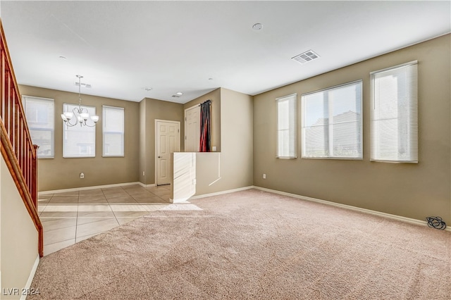 empty room with light carpet and an inviting chandelier