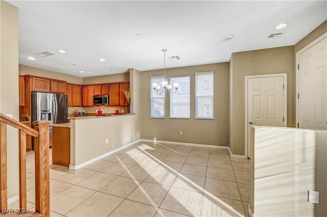 kitchen featuring light tile patterned floors, kitchen peninsula, decorative light fixtures, a chandelier, and appliances with stainless steel finishes