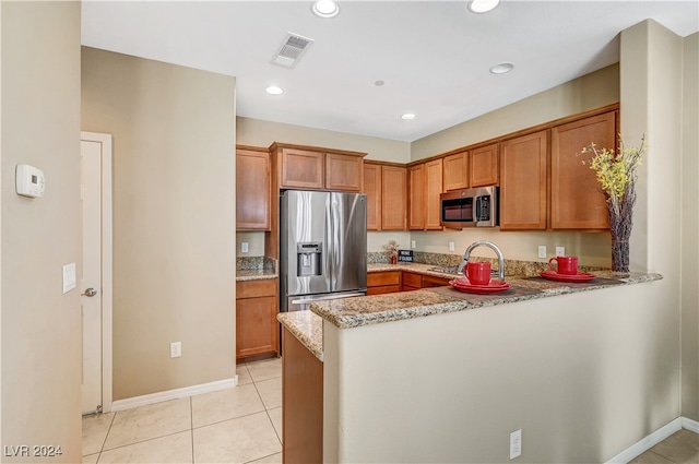 kitchen featuring light stone counters, light tile patterned flooring, appliances with stainless steel finishes, and kitchen peninsula