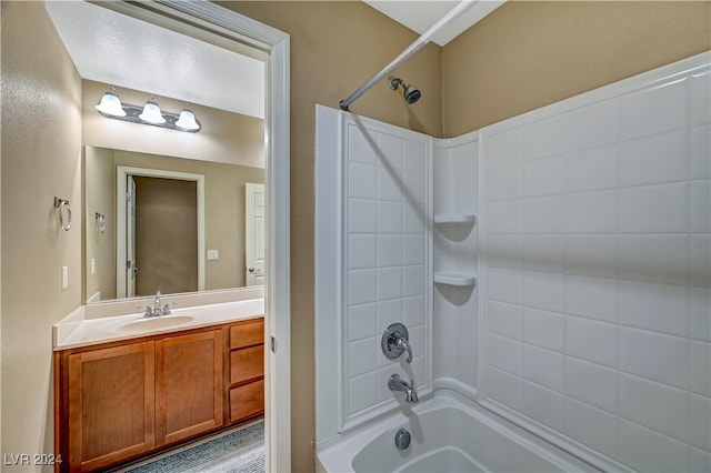 bathroom featuring tiled shower / bath and vanity