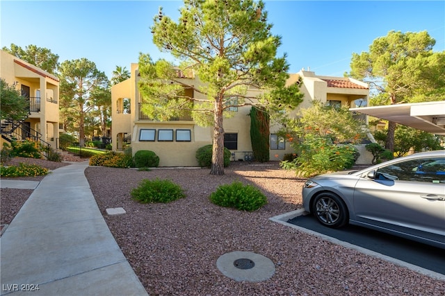 view of front of property with a carport and a balcony