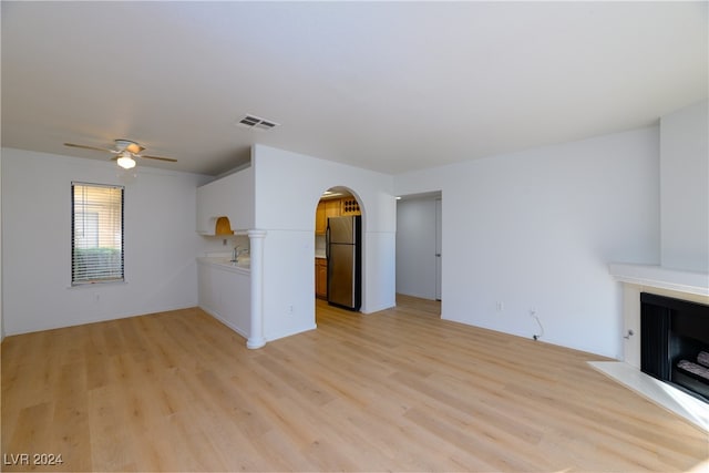 unfurnished living room with ceiling fan, light hardwood / wood-style flooring, and sink