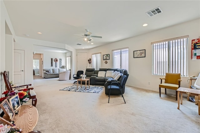 living room featuring ceiling fan, light colored carpet, and plenty of natural light