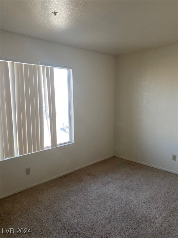 carpeted spare room with a textured ceiling