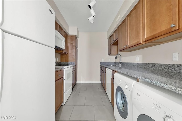 kitchen featuring rail lighting, light tile patterned floors, independent washer and dryer, sink, and white appliances