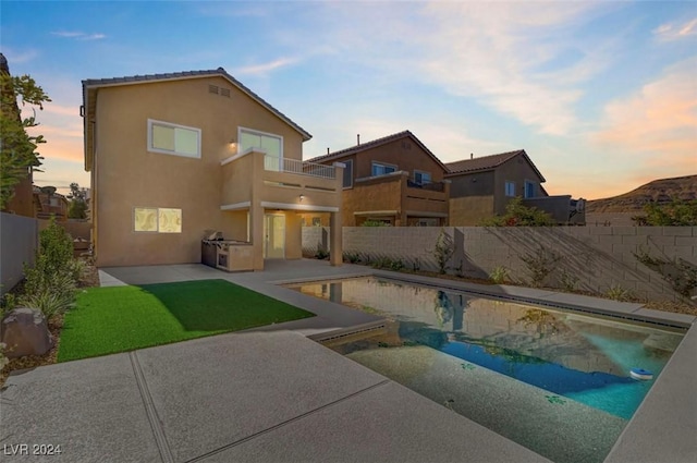 pool at dusk featuring a patio