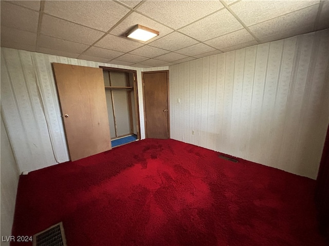 unfurnished bedroom featuring a closet and a paneled ceiling