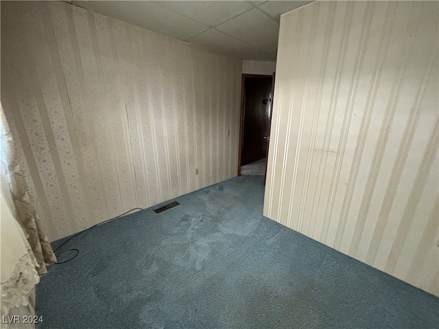 unfurnished room featuring a paneled ceiling and carpet