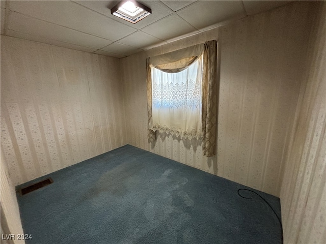 unfurnished room featuring carpet floors and a drop ceiling