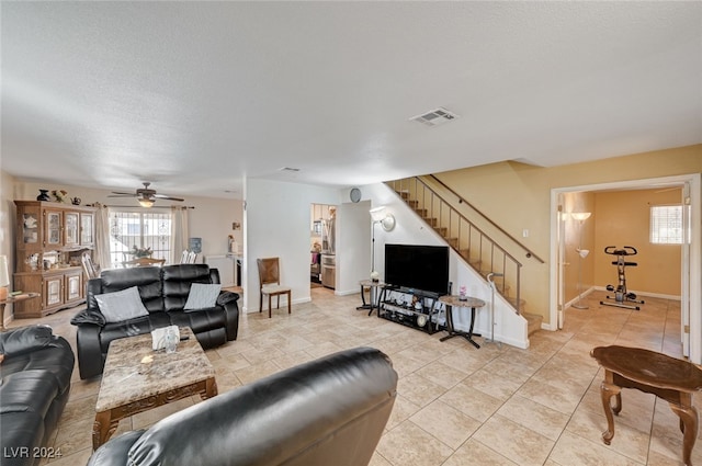 living room featuring ceiling fan, a textured ceiling, and light tile patterned floors