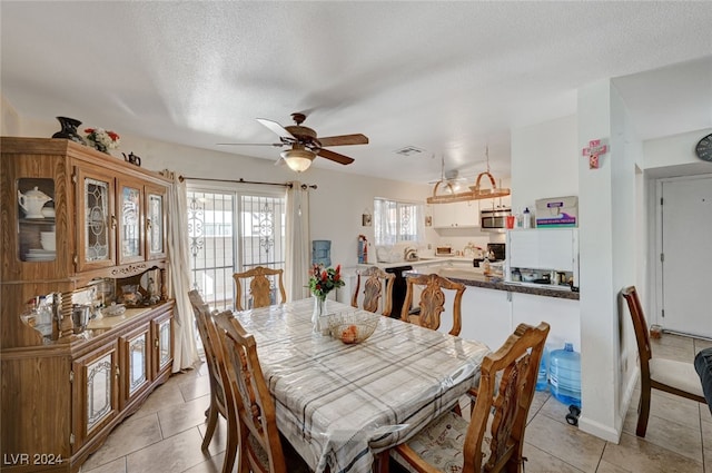 tiled dining area featuring ceiling fan and a textured ceiling