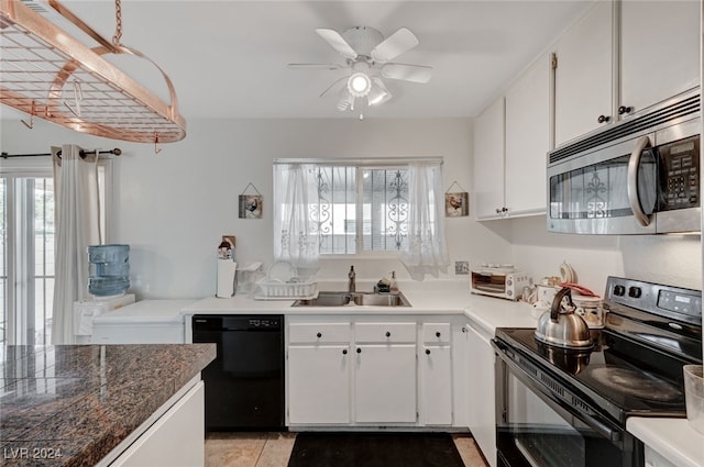 kitchen with white cabinetry, black appliances, sink, and a healthy amount of sunlight