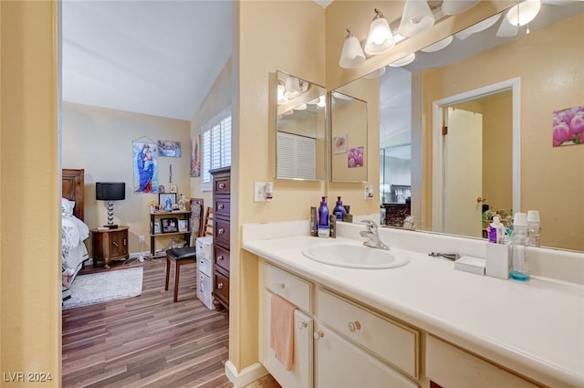 bathroom featuring vaulted ceiling, hardwood / wood-style flooring, and vanity