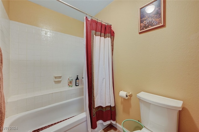 bathroom featuring shower / bathtub combination with curtain and toilet