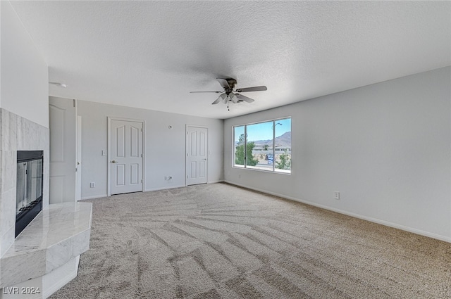 unfurnished living room featuring light colored carpet, a textured ceiling, and ceiling fan