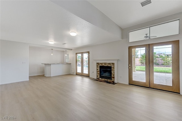 unfurnished living room with french doors, light wood-type flooring, and a wealth of natural light