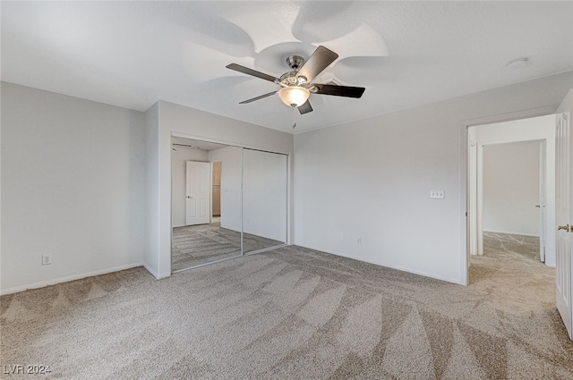 unfurnished bedroom featuring ceiling fan, a closet, and light colored carpet