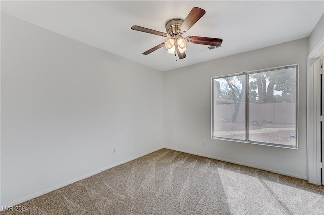 carpeted spare room with ceiling fan