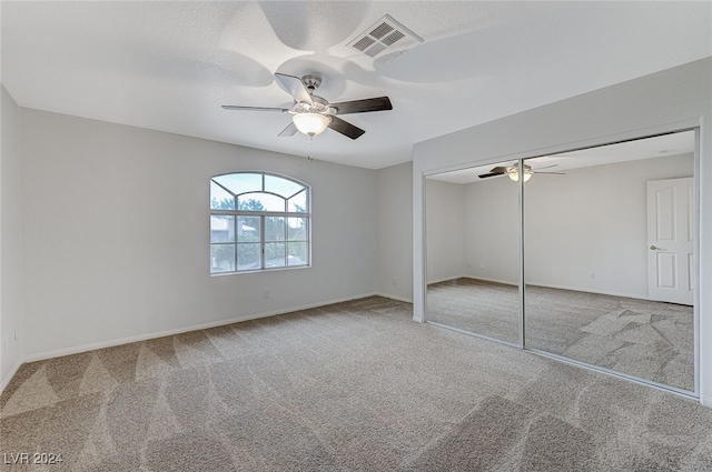 unfurnished bedroom with a closet, carpet flooring, and ceiling fan