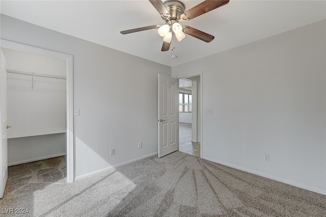 unfurnished bedroom with a closet, light carpet, and ceiling fan