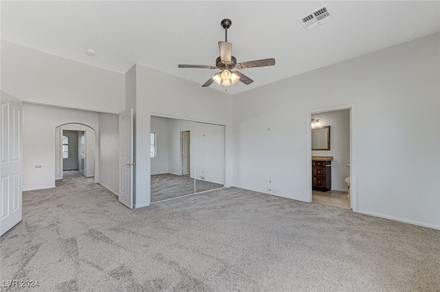 unfurnished bedroom with ceiling fan, light colored carpet, and a closet