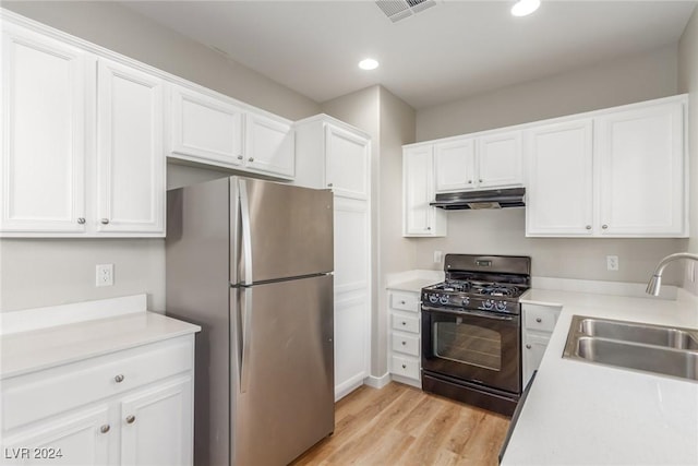 kitchen featuring black gas range, stainless steel refrigerator, white cabinetry, sink, and light wood-type flooring