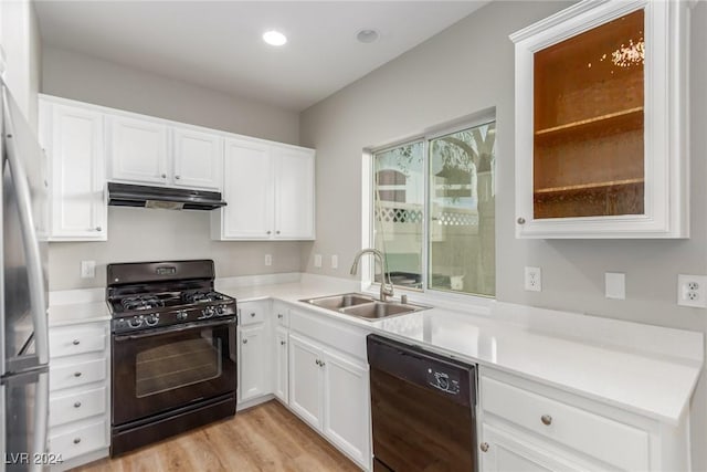 kitchen featuring white cabinetry, sink, black appliances, and light wood-type flooring