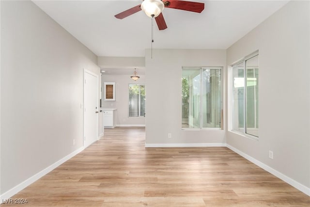 empty room featuring plenty of natural light, light hardwood / wood-style floors, and ceiling fan