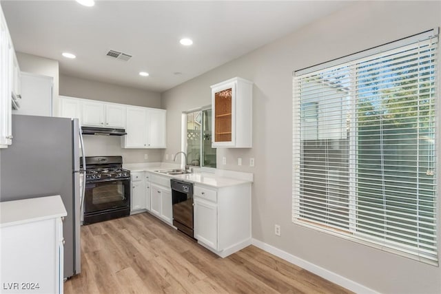 kitchen featuring white cabinets, light wood-type flooring, sink, and black appliances