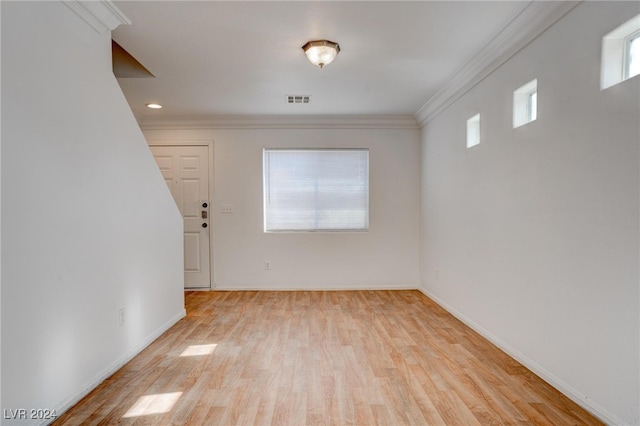 spare room with crown molding and light hardwood / wood-style flooring