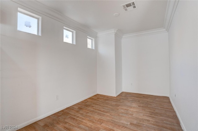 spare room featuring ornamental molding and light wood-type flooring