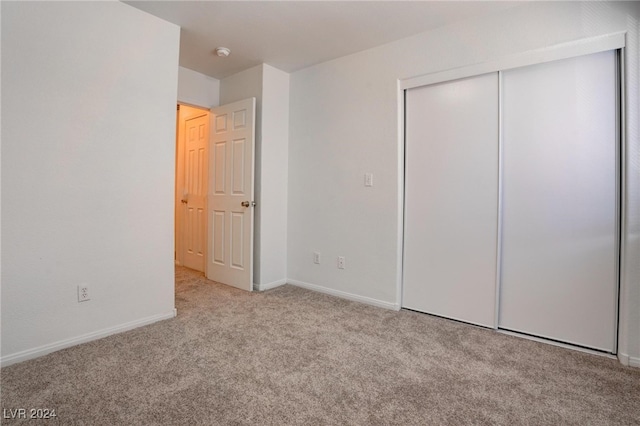 unfurnished bedroom with a closet and light carpet