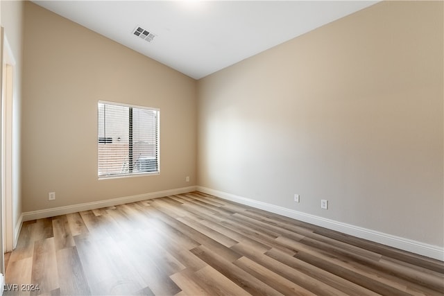 unfurnished room featuring high vaulted ceiling and light hardwood / wood-style floors