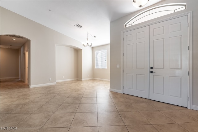 entryway featuring light tile patterned floors and a chandelier