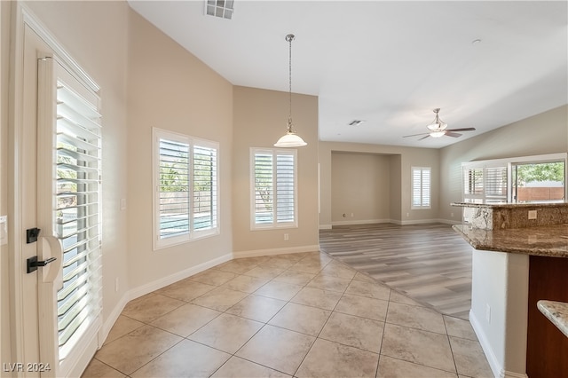 interior space with light wood-type flooring, ceiling fan, and lofted ceiling