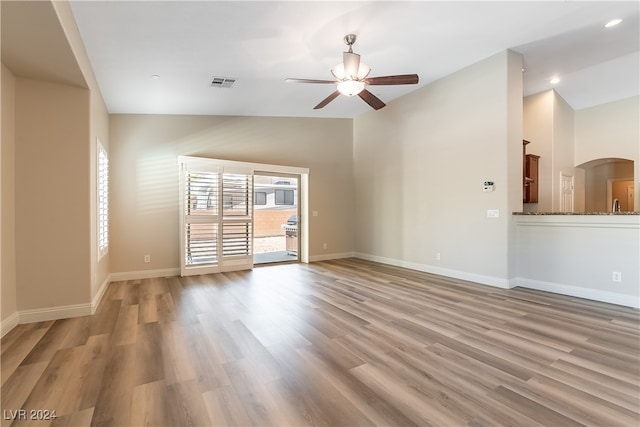 unfurnished living room featuring high vaulted ceiling, ceiling fan, and light hardwood / wood-style floors