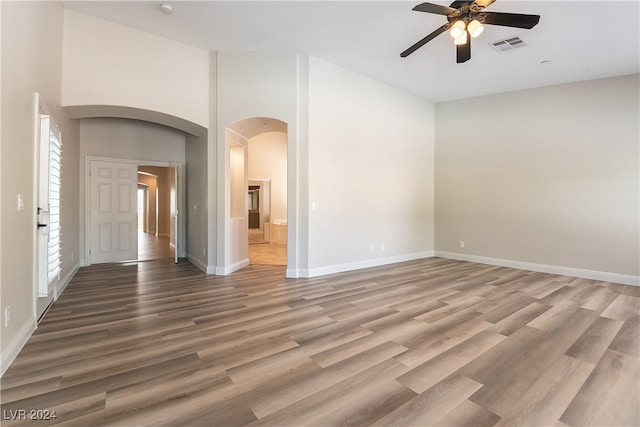 spare room with ceiling fan, hardwood / wood-style floors, and a high ceiling