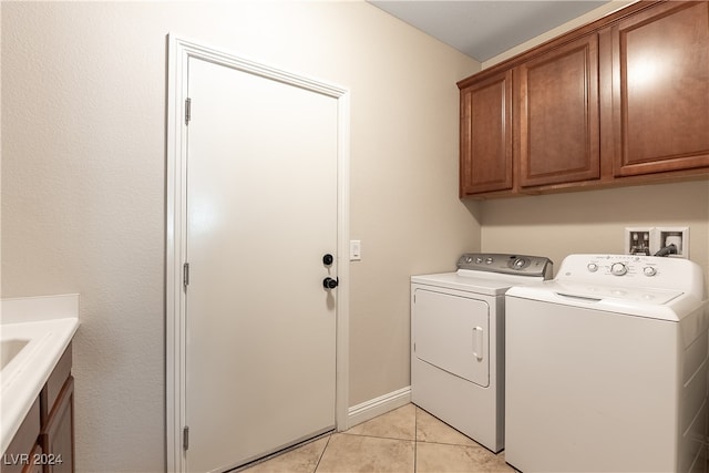 washroom featuring light tile patterned floors, cabinets, and washer and dryer