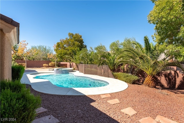 view of swimming pool featuring a patio and an in ground hot tub