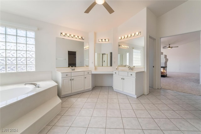 bathroom with a bathing tub, ceiling fan, tile patterned flooring, and vanity