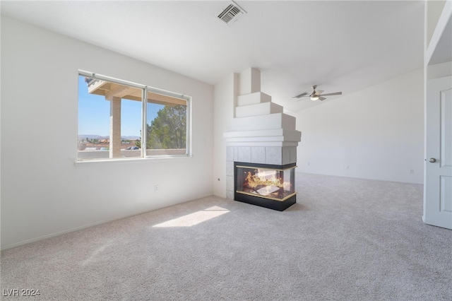 unfurnished living room featuring carpet floors, a multi sided fireplace, and ceiling fan