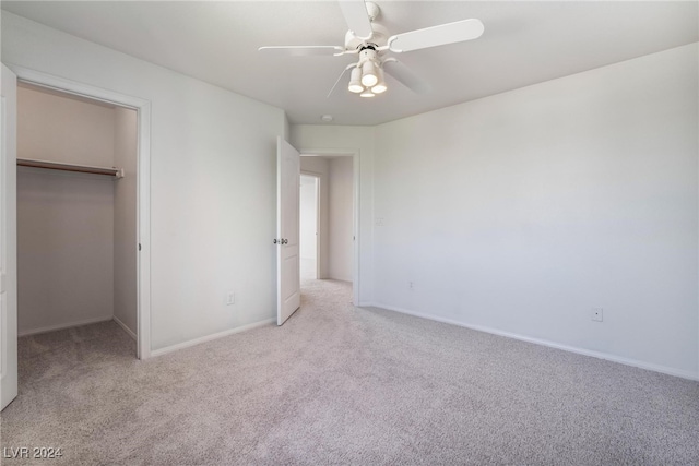 unfurnished bedroom featuring ceiling fan, a closet, and light colored carpet