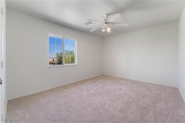 empty room featuring ceiling fan and carpet