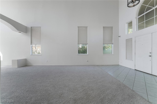 foyer entrance featuring a towering ceiling and tile patterned flooring