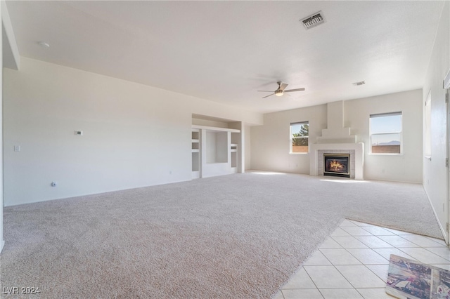 unfurnished living room featuring ceiling fan and light colored carpet