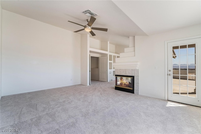 unfurnished living room with ceiling fan, light colored carpet, and a fireplace