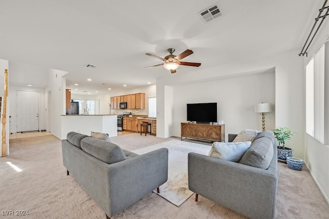 carpeted living room featuring ceiling fan and a wealth of natural light