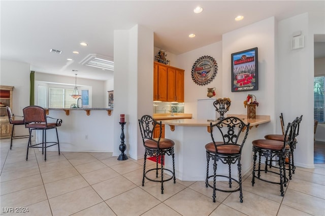 kitchen featuring kitchen peninsula, a wealth of natural light, and a breakfast bar