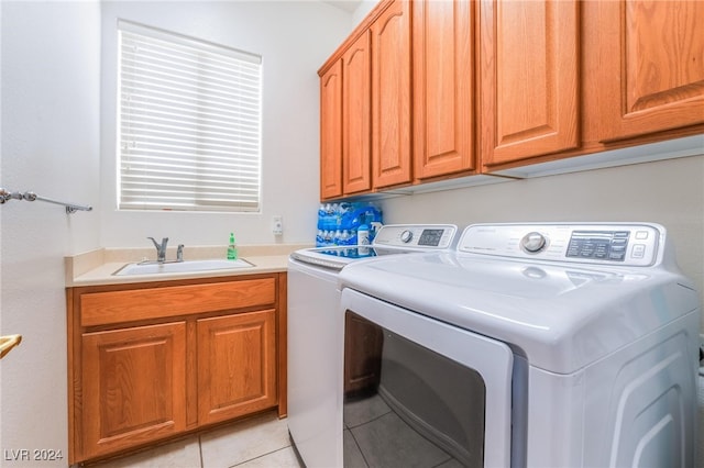 clothes washing area featuring cabinets, sink, washing machine and dryer, and light tile patterned flooring