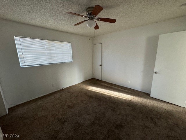 carpeted empty room featuring ceiling fan and a textured ceiling